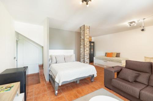 a living room with a couch and a bed at Villa Ana Esperanza - El Espinar in El Espinar