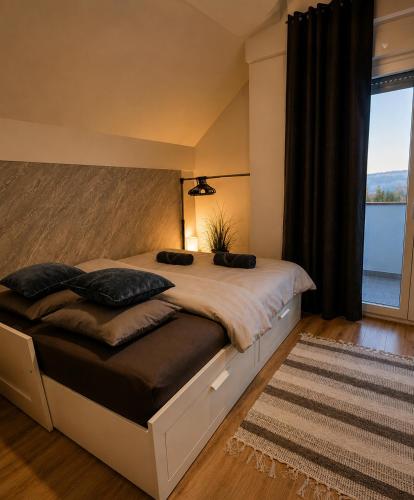 a bedroom with a large bed with a large window at Casa Cordis in Korduševci