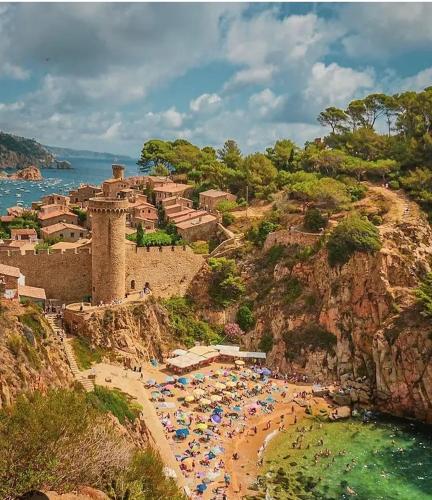 a beach with a bunch of umbrellas and people on it at Parascheva St Jordi in Tossa de Mar