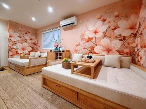a living room with two beds and flowers on the wall at 刻宿Toki Stay Ueno in Tokyo