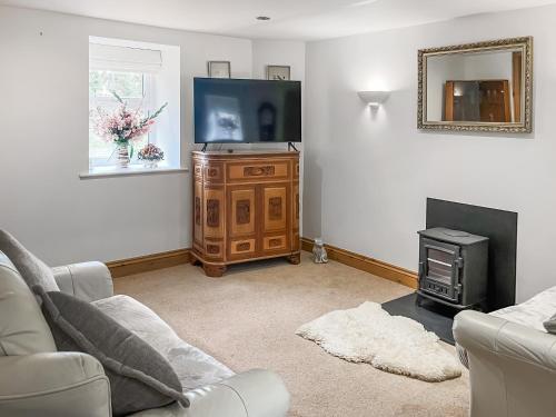 a living room with a flat screen tv and a couch at Coach House in Holsworthy