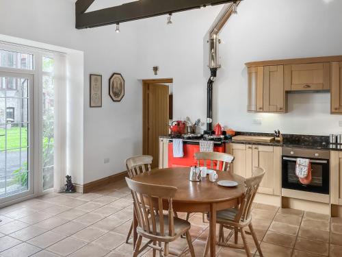a kitchen with a wooden table and chairs in it at Coach House in Holsworthy