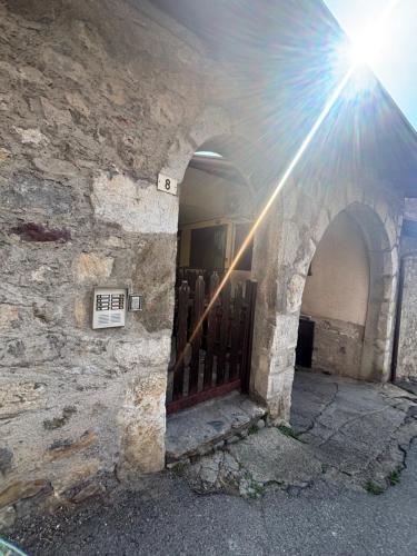 a sun shines through an archway in a stone wall at Sotto il castello in Borno