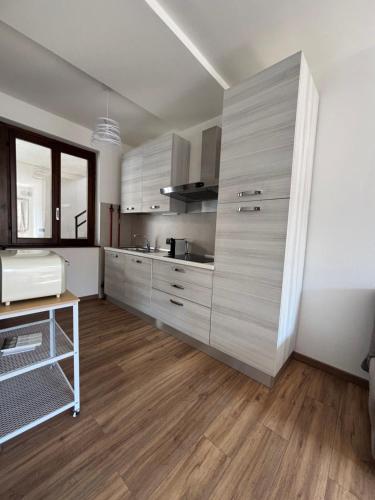 a large kitchen with wooden floors and white walls at Sotto il castello in Borno
