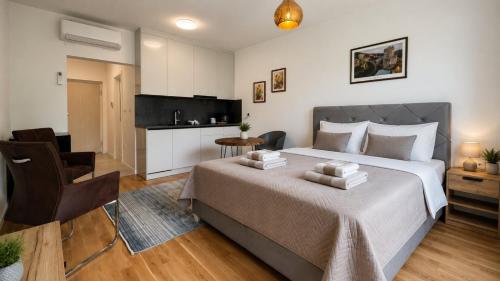 a bedroom with a large bed and a kitchen at Salt Oasis Apartment Tuzla in Tuzla