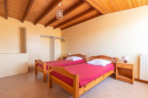 two beds in a room with wooden ceilings at Duplex N°6 - Résidence Balnéaire in Le Port-des-Barques