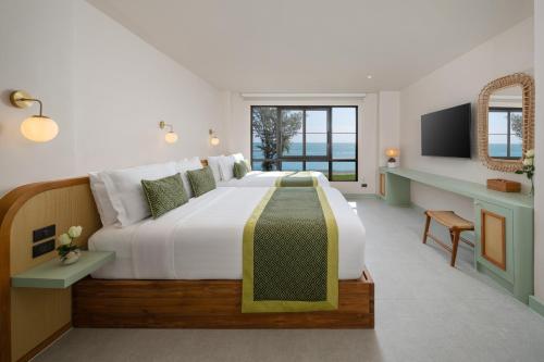 a bedroom with a large bed and a television at Anantasila Beach Resort Hua Hin in Hua Hin