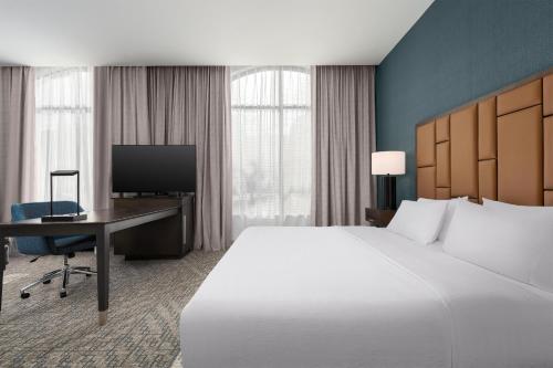 a hotel room with a bed and a desk and a television at Hampton Inn & Suites Memphis Germantown in Memphis