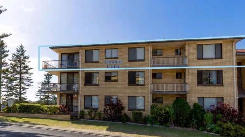 a large brick building with a sign on it at Flinders Lodge Unit 5 - Lifestyle Yamba in Yamba