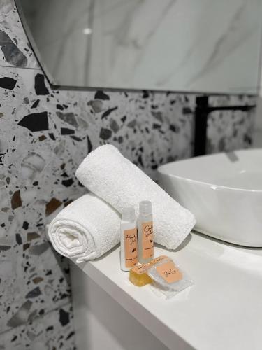 a bathroom with a sink and towels on a counter at The Legacy Hotel and Spa in Tzaneen