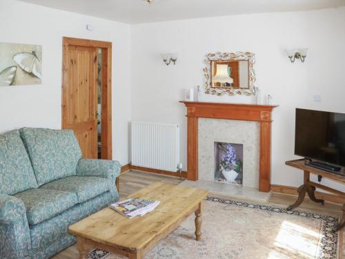 a living room with a couch and a fireplace at Weaver's Cottage in Banchory