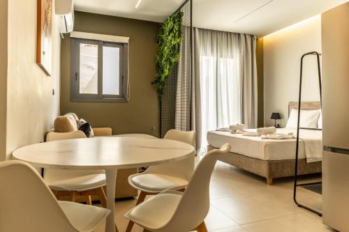 a room with a bed and a table and chairs at Baja Suites in Kalamata