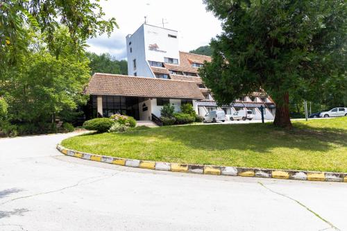 a building with a tree in front of a street at Everest Hotel in Etropole
