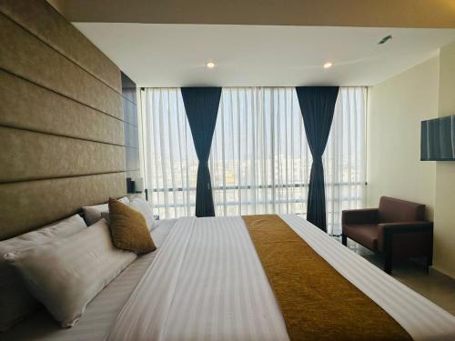 ein Schlafzimmer mit einem großen Bett und einem großen Fenster in der Unterkunft White Park Hotel & Suites in Chittagong
