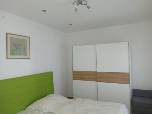 a bedroom with a green and white bed and a cabinet at Apartment Gms in Schottwien