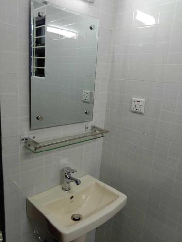 a white bathroom with a sink and a mirror at White Park Boutique Hotel in Chittagong