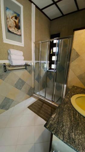 a bathroom with a shower with towels on a counter at Villa Mistora in Kandy