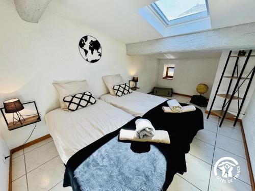 a bedroom with two beds and a skylight at Le carpe diem in Pomas