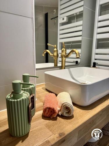 a bathroom counter with a sink and a tub at Le carpe diem in Pomas