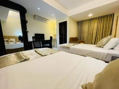 a hotel room with two beds and a desk at White Park Boutique Hotel in Chittagong