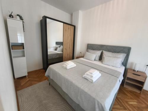 a bedroom with a large mirror and a bed at Apartman-Zara m in Zadar