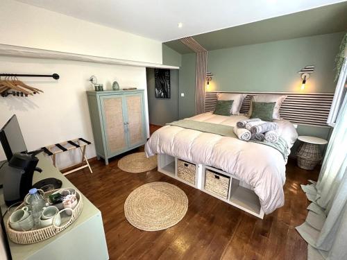 a bedroom with a bed and a desk with a television at Maison le baron in Bélus