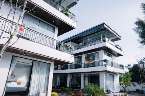 a white apartment building with balconies at Home Mộc Mer Mộc Châu in Mộc Châu