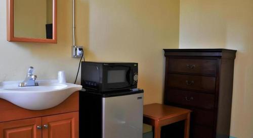 a bathroom with a sink and a tv on a counter at Desmond Hotel in San Francisco