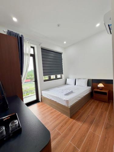 a bedroom with a bed and a large window at The Haven Motel in Chú Cư
