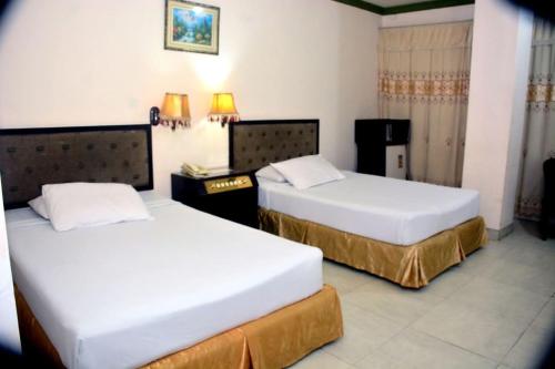 two beds in a hotel room with two beds at Hotel City Inn in Chittagong