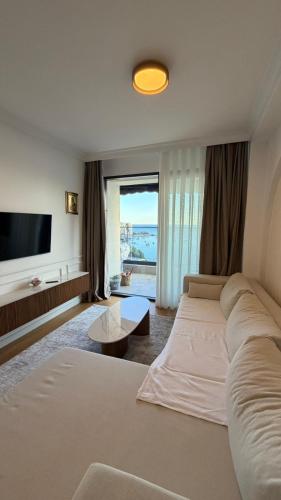a large living room with a large couch and a tv at Perla Petrus in Rafailovici