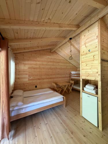 a log cabin with a bed in a room at Riverside - Mountain Stay with Sauna in Vusanje