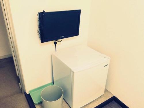a small refrigerator with a flat screen tv on a wall at HOTEL LUCKY / Vacation STAY 4266 in Osaka