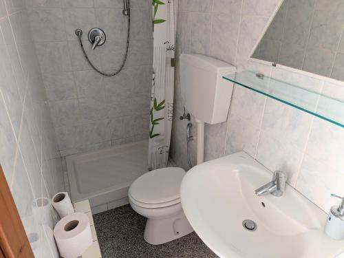 a white bathroom with a toilet and a sink at Affittacamere Pietra Lucente in Riomaggiore