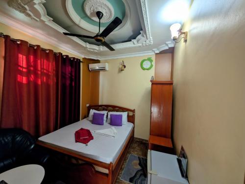 a room with a bed with purple pillows and a ceiling at New Africa one inn in Dar es Salaam