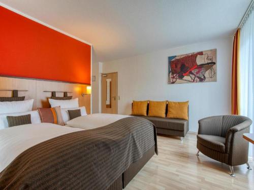 a hotel room with two beds and a couch at Stuttgart Großbettlingen Hotel by Belvilla in Großbettlingen
