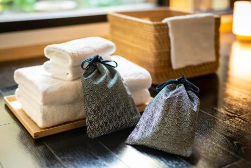 a wooden table with towels and a basket of towels at Higashiyama Kageroi in Kanazawa