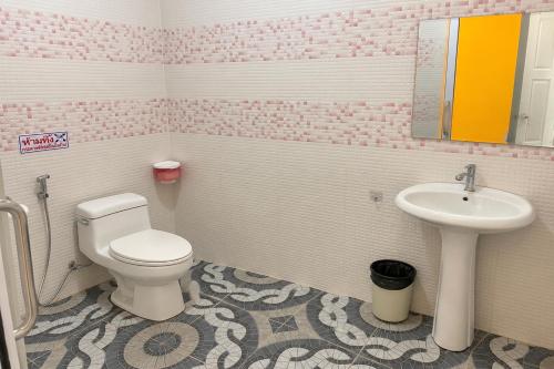 a pink bathroom with a toilet and a sink at White House Hotel Kamphaeng Phet in Ban Tha Dua