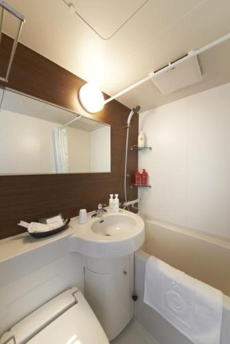 a bathroom with a sink and a toilet and a mirror at Hotel Sun Clover Koshigaya Station - Vacation STAY 55366 in Koshigaya