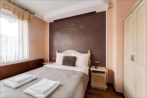 a bedroom with a large bed with two towels on it at Willa Sichelscy - apartamenty i pokoje z aneksami kuchennymi - rabat 20 procent na Termy Szaflary oraz Gorący Potok oraz 15 procent rabatu na Bramę Gorce in Biały Dunajec