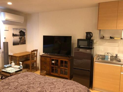 a living room with a television and a kitchen at Time - Vacation STAY 18889v in Kagoshima