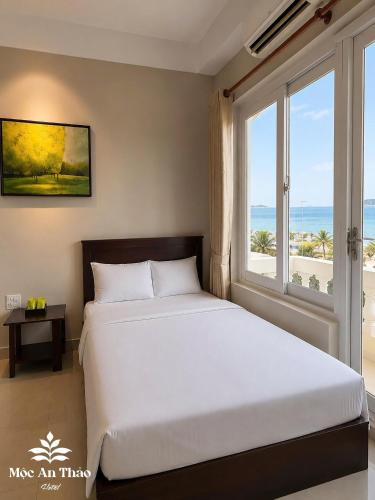 a bedroom with a bed and a large window at Mộc An Thảo Hotel in Quy Nhon