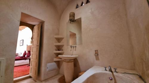 a bathroom with a tub and a sink and a mirror at Tagadert Lodge in Oumnas
