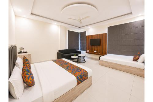a hotel room with two beds and a television at FabHotel K9 Regency in Zirakpur