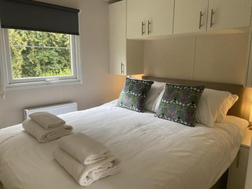 a bedroom with a white bed with towels on it at Cherry Tree Glamping in Stroud