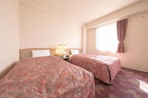 a hotel room with two beds and a window at Main Hotel - Vacation STAY 85327v in Miyakonojō