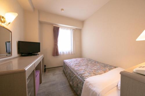a hotel room with a bed and a television at Main Hotel - Vacation STAY 60460v in Miyakonojō