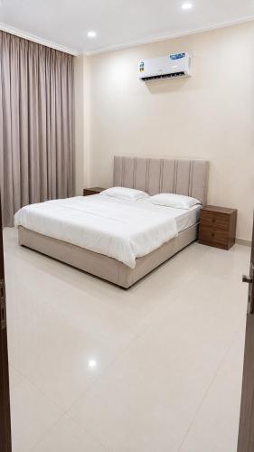 a bedroom with a bed and a white floor at بناية حمران-RED-9-Hamren in Ma‘mūrah