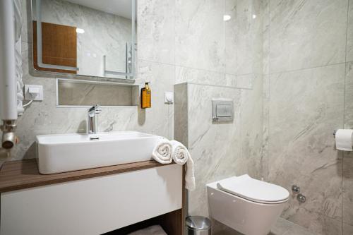 a bathroom with a white sink and a toilet at Alexander Resort in Sopot