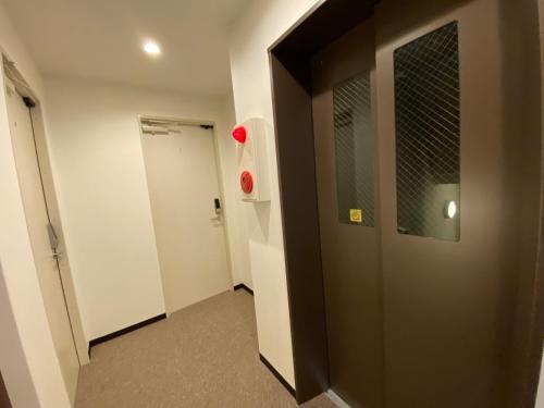 a hallway with a brown door and a white wall at winco - Vacation STAY 06648v in Tokyo